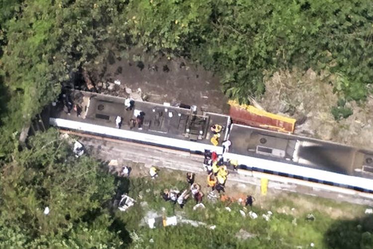 Dalam foto yang dirilis oleh Badan Pemadam Kebakaran Nasional ini, petugas penyelamat terlihat di dekat lokasi kereta yang tergelincir sebagian di wilayah Hualien timur Taiwan, Jumat (2/3/2021).