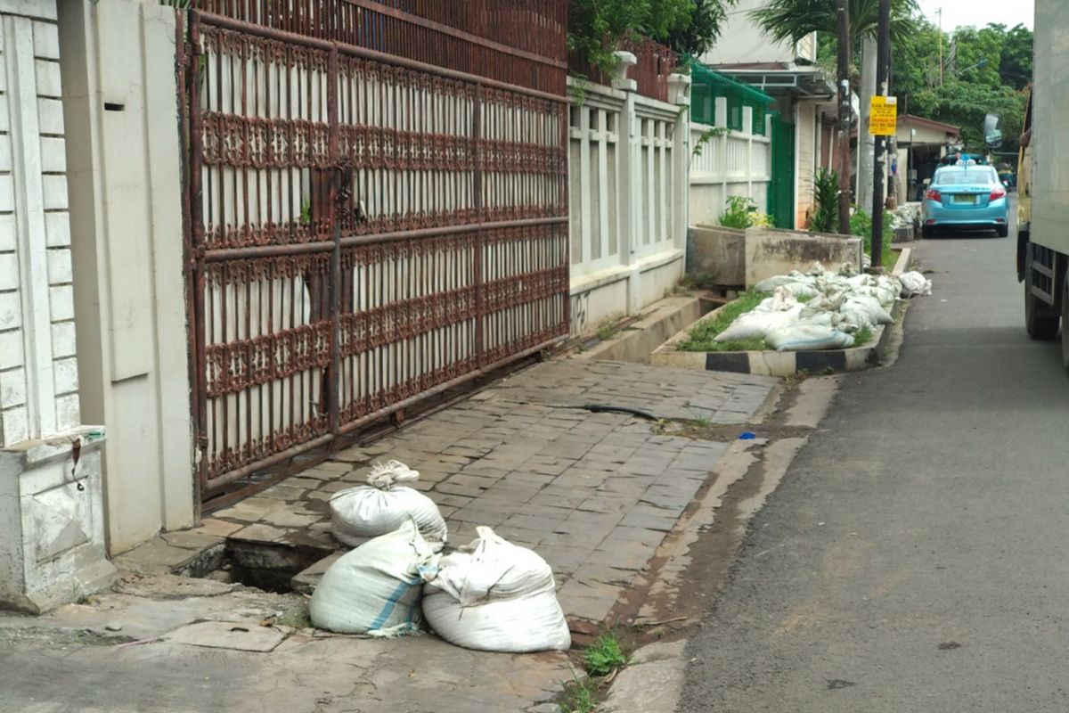 Pekerja kebersihan sedang melakukan pembersihan saluran air dari lumpur di RT 02 RW 08 Kelurahan Sunter Jaya, Selasa (21/11/2017). Sebelumnya wilayah ini mendapat sorotan karena pengurus RT 02 menyebarkan edaran untuk dana iuran kebersihan dan menjadi viral di media sosial.