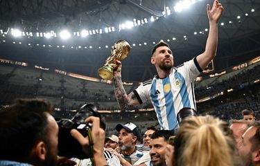 Lionel Messi mengangkat trofi Piala Dunia 2022 usai Argentina meraih kemenangan atas Perancis dalam laga final Piala Dunia 2022 di Stadion Lusail, Doha, Qatar, 18 Desember 2022. (Photo by Anne-Christine POUJOULAT / AFP)