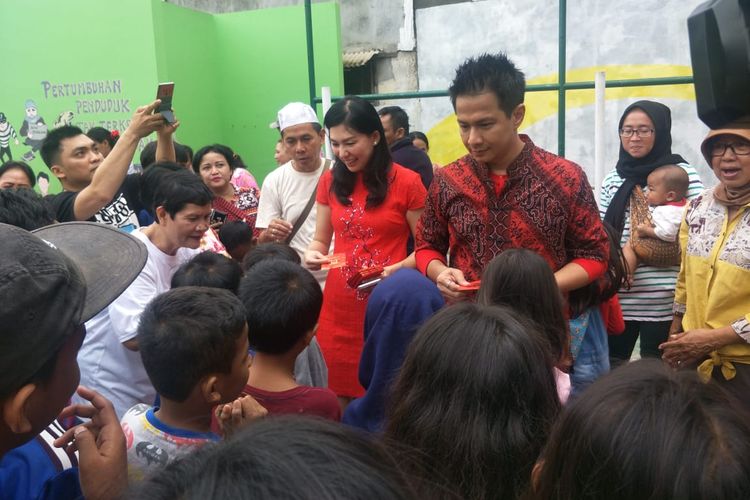 Delon Thamrin dan istrinya Aida Chandra membagikan angpau kepada anak-anak saat merayakan Imlek di kawasan Kebon Jeruk, Jakarta Barat, Sabtu (25/1/2020).