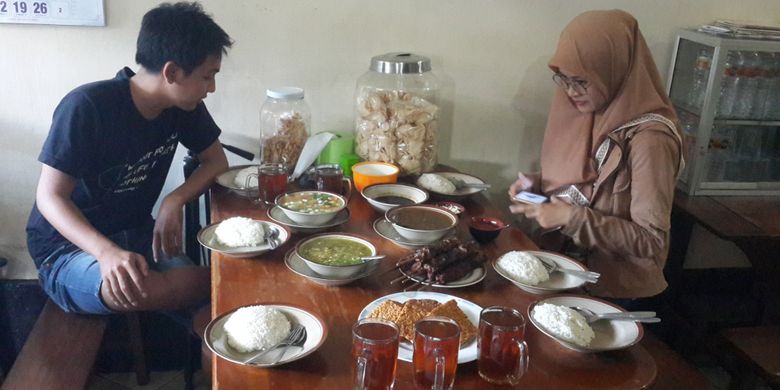 Pengunjung saat menikmati menu masakan di Warung Sate Gebug, Kota Malang, Jawa Timur, Minggu (20/1/2019).
