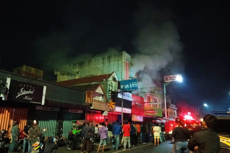 Petugas berupaya memadamkan api yang membakar toko Star