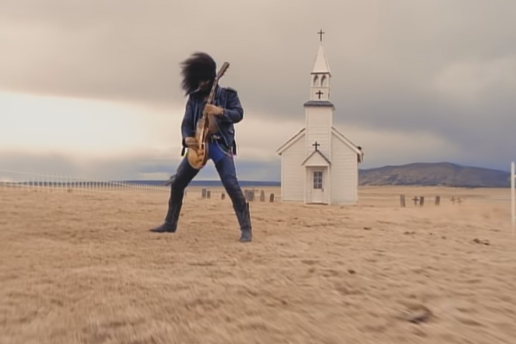 Tangkapan layar video klip November Rain, adegan ikonik ketika Slash memainkan solo gitar di depan sebuah kapel berwarna putih di tengah gurun.
