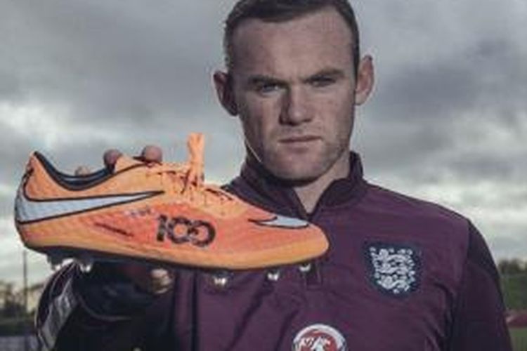 Wayne Rooneye memamerkan sepatu barunya yang khusus dibuat untuk menandai laga ke-100 bersama tim nasional Inggris.