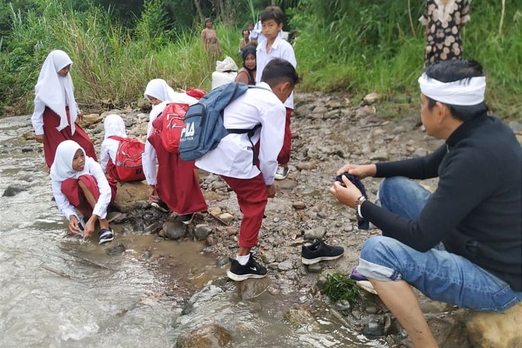 Sejumlah siswa SD asal Kampung Cigarukgak, Desa Sukatani, Kecamatan Sukatani, Purwakarta, Jawa Barat, menyeberangi sungai demi bersekolah, Selasa (25/10/2022).