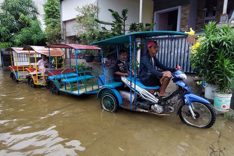 Dodi (25) sopir kereta keliling bermotor untuk anak-anak atau biasa disebut odong-odong, terkena imbas banjir yang terjadi di sejumlah wilayah di Tegal Alur, Kalideres, Jakarta Barat. 