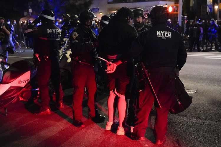 Petugas Kepolisian New York berbicara dengan orang-orang yang ditangkap selama demonstrasi, Rabu, 4 November 2020, di New York.