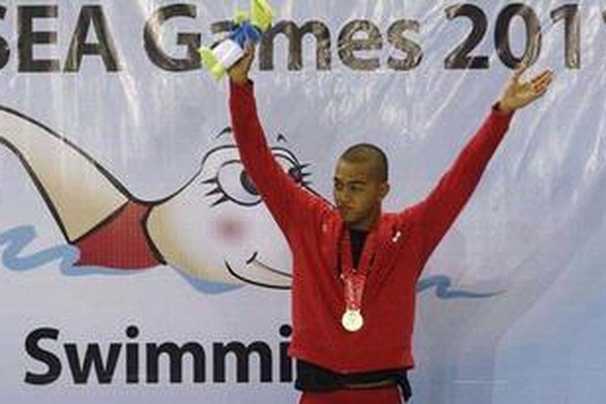 Perenang Indonesia, Sudartawa, melambaikan tangan kepada penonton seusai pengalungan medali dalam lomba renang 200 meter gaya punggung putra di Stadion Renang, Jakabaring, Sumatera Selatan, Senin (14/11). Sudartawa kembali menyumbang perolehan medali emas untuk cabang renang di nomor tersebut dengan catatan waktu 2:02:.44 detik.