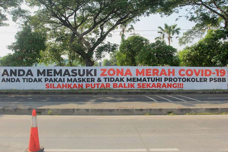 Foto dirilis Kamis (25/6/2020), memperlihatkan sebuah spanduk bernada peringatan terpasang di pagar jalan di akses keluar Jembatan Suramadu, Surabaya, Jawa Timur. Sekitar 4.312 aparat gabungan diterjunkan guna mengamankan pelaksanaan PSBB di Kota Surabaya, Kabupaten Gresik, dan Kabupaten Sidoarjo, yang tiga kawasan itu lebih dikenal dengan Surabaya Raya.