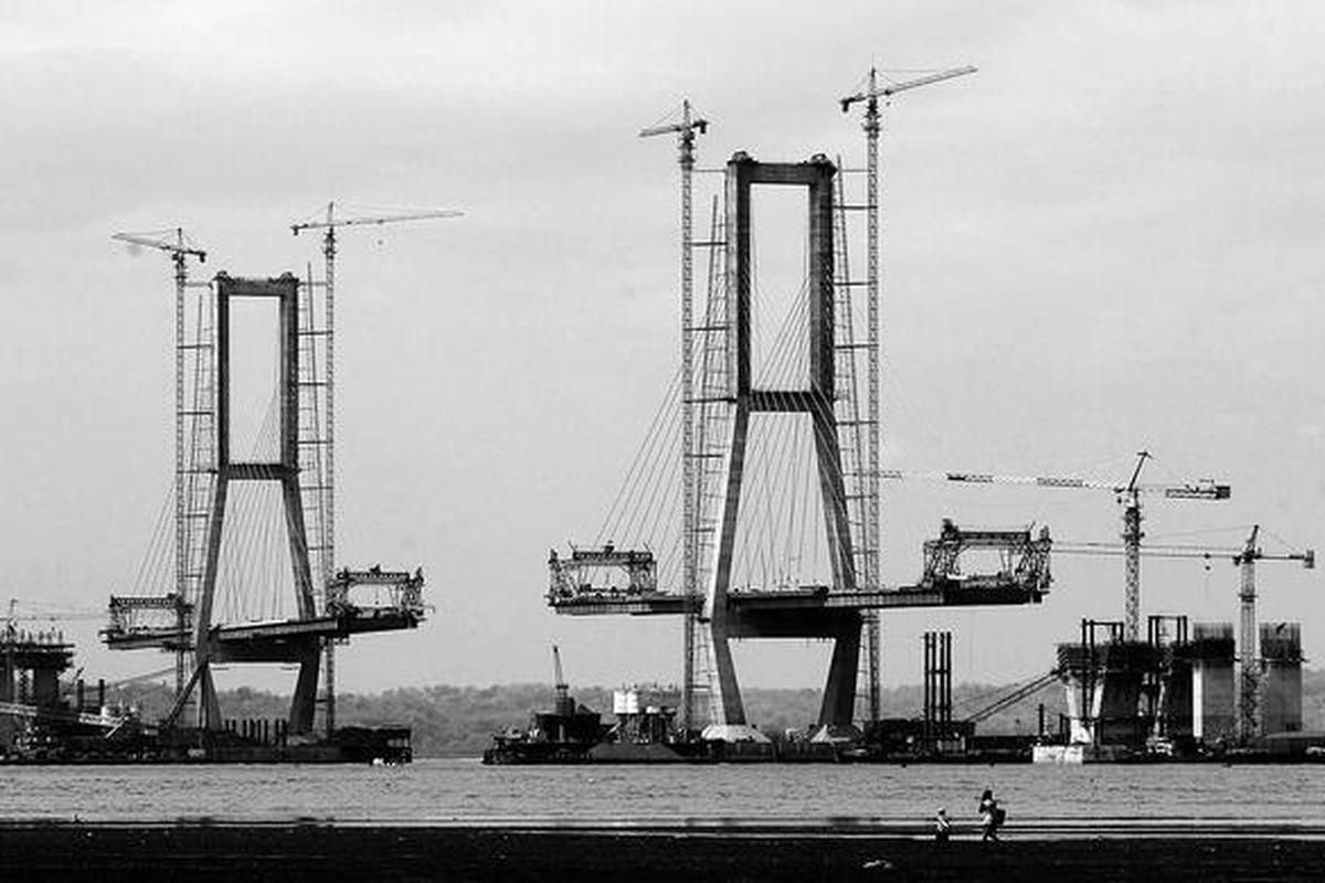 Proyek pembangunan Jembatan Suramadu, penghubung Surabaya dan Madura, dilihat dari sisi Surabaya, Selasa (7/10). Pengerjaan jembatan saat ini memasuki tahap pemasangan cable stay dan sudah rampung 83,95 persen. Pembangunan jembatan tersebut terus dikebut dan hanya libur dua hari saat hari raya Idul Fitri agar rampung pada Maret 2009.  
