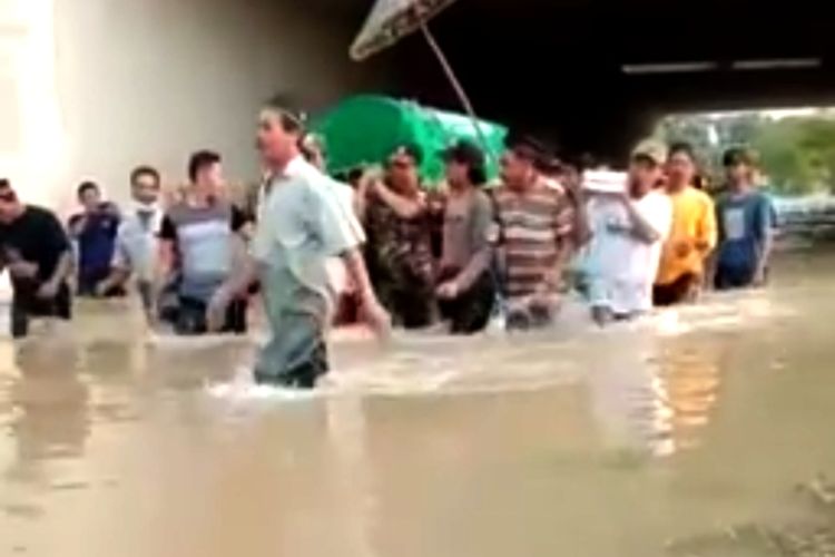 Viral, video yang memperlihatkan puluhan warga menerobos banjir sambil membawa keranda mayat. Dari penelusuran, peristiwa itu terjadi di Dusun Kedunggabus, Desa Bandar Kedungmulyo, Kabupaten Jombang, Kamis (11/2/2021).