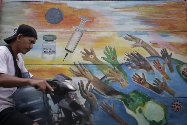 Warga melintas di depan mural bertema vaksin COVID-19 di Tanah Tinggi, di Kota Tangerang, Banten, Senin (22/11/2021). ANTARA FOTO/Fauzan/hp.