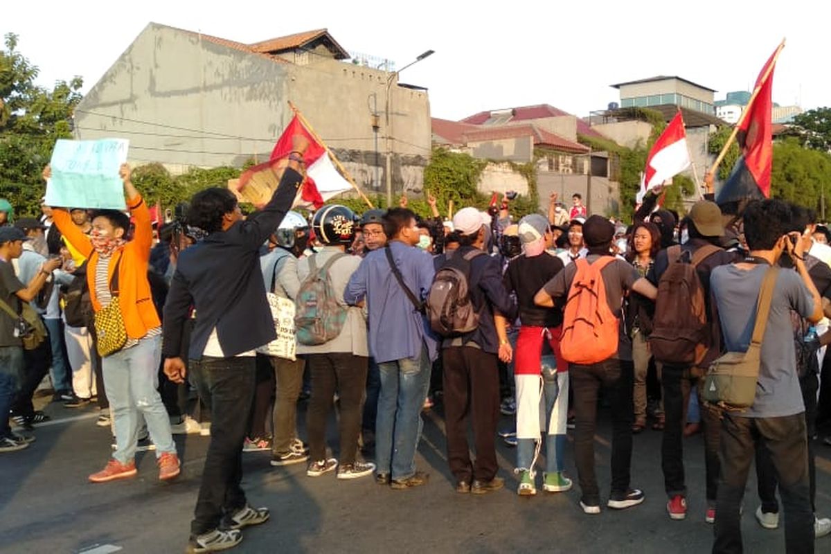 Massa yang memakai almamater mahasiwa menahan massa lain yang melempari polisi di depan restoran Pulau Dua, Senayan, Jakarta Pusat, Senin (30/9/2019)