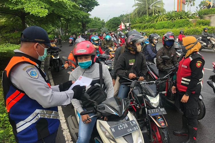 Hari kedua pembatasan sosial berskala besar (PSBB) di Surabaya, arus lalu lintas di perbatasan Surabaya dan Sidoarjo, Jawa Timur, tepatnya di Bundaran Waru, terpantau lancar, Rabu (29/4/2020). Meski kendaraan terlihat padat, arus lalu lintas terpantau lancar.