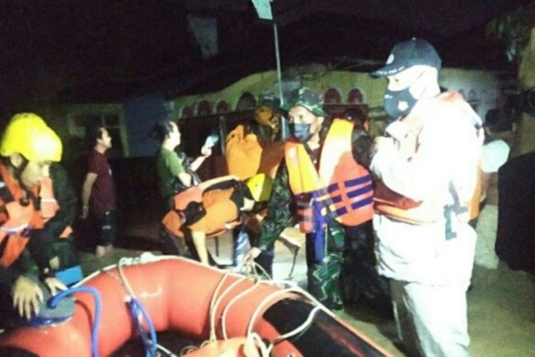Tim SAR gabungan di antaranya Polri, TNI dan Basarnas saat evakuasi warga yang terjebak banjir di Manado. Warga dievakuasi menggunakan perahu karet.