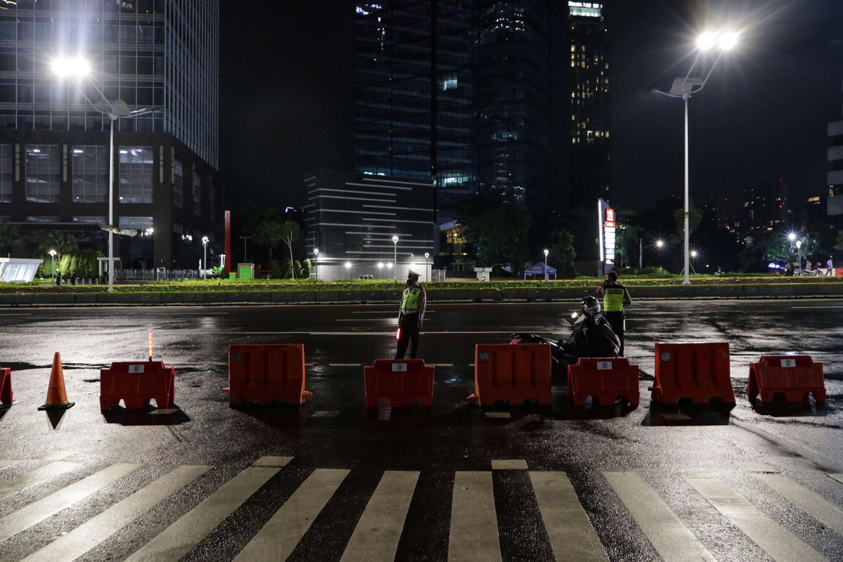 Petugas berjaga di Jalan Sudirman, Jakarta, yang tampak lengang, Kamis (31/12/2020). Untuk mencegah kerumunan pada malam Tahun Baru 2021 dan penyebaran virus Covid-19, Pemprov DKI Jakarta bersama Polda Metro Jaya memberlakukan pengendalian ketat dan penutupan sejumlah lokasi mulai dari ruas jalan hingga fasilitas publik pada 31 Desember 2020 dan 1 Januari 2021.