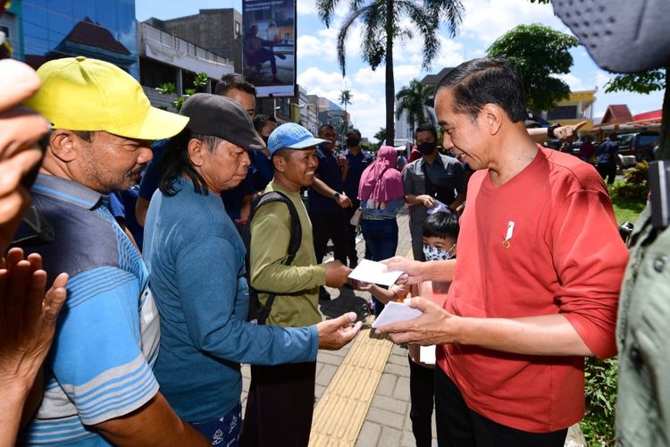 Presiden Joko Widodo saat membagikan sejumlah THR untuk para pedagang di Pasar Legi, Kota Solo, Jawa Tengah, Kamis (20/4/2023).