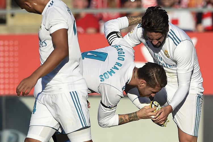 Bek Real Madrid, Sergio Ramos (tengah), memberikan ucapan dengan cara mencium sepatu Isco yang mencetak gol ke gawang Girona dalam pertandingan La Liga di Stadion Montilivi, Girona, Minggu (29/10/2017).