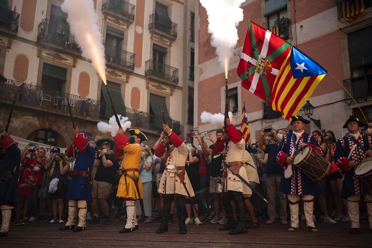 Pria berpakaian kostum menembakkan senapan mereka selama pertunjukan untuk merayakan Hari Nasional Catalonia di Barcelona, Spanyol, Sabtu, 11 September 2021.