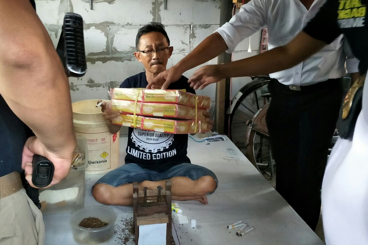 Tersangka THG alias Gino menunjukkan rokok yang dia produksi dengan memalsukan merk dagang salah satu rokok, Selasa (12/2/2018). Atas perbuatannya, THG dan 3 orang lainnya ditangkap Unit Reskrim Polsek Metro Setiabudi.