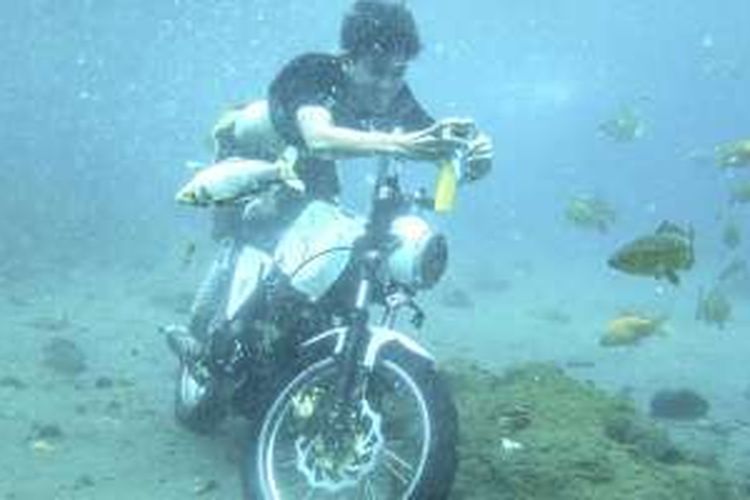 Wisatawan berfoto dengan sepeda motor yang sengaja diparkir sebagai tambahan obyek foto di dasar obyek wisata Umbul Ponggok di Desa Polanharjo, Kabupaten Klaten, Jawa Tengah, Minggu (14/8/2016).