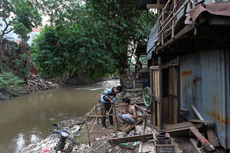 Suasana kehidupan warga di Kebon Pala di bantaran Kali Ciliwung, Jakarta Timur, Senin (7/6/2021). Pemerintah Provinsi DKI Jakarta membuka pendaftaran data Fakir Miskin dan Orang Tidak Mampu (FMOTM), nantinya akan digunakan sebagai dasar pemberian program bantuan dari Pemprov DKI Jakarta.