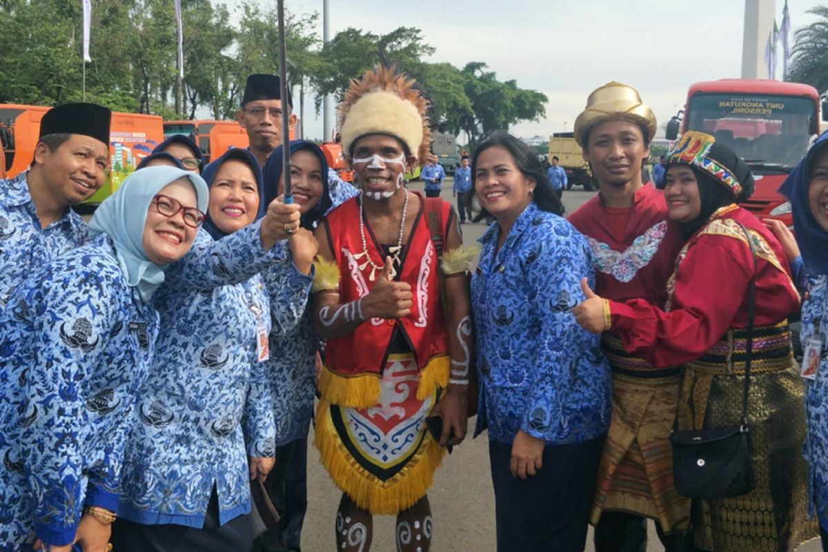 Sejumlah aparatur sipil negara berswafoto (selfie) usai mengikuti upacara Peringatan Hari Ulang Tahun Ke-46 Korps Pegawai Republik Indonesia (Korpri) di lapangan silang Monumen Nasional (Monas) Selatan, Jakarta Pusat, Rabu (29/11/2017).