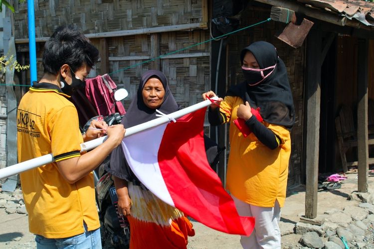 Dua pemuda Demak yang tergabung dalam JKP 4/2 mengikat bendera baru untuk Mbah     Parminah di Desa Karangsari Kecamatan Karangtengah Kabupaten  Demak Jawa Tengah ,  sebagai pengganti bendera lama yang kecil dan lusuh, Kamis (6/8/2020)