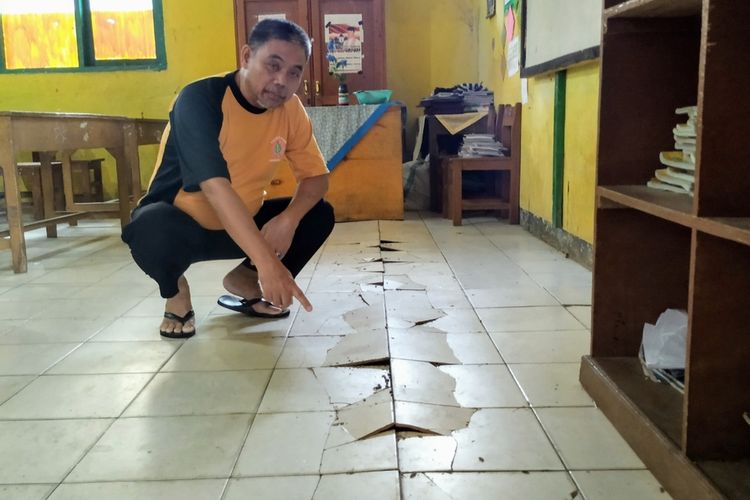 Guru kelas 2 Maman Sulaeman menunjukkan lantai keramik yang retak di ruang kelasnya di SDN 10 Desa Sekarwangi, Kecamatan Cibadak, Sukabumi, Jawa Barat, Jumat (10/01/2020).