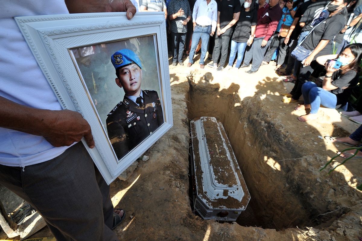 Kerabat memegang foto almarhum Brigadir Nofriansyah Yosua Hutabarat atau Brigadir J saat pemakaman kembali jenazah setelah autopsi ulang di Sungai Bahar, Muarojambi, Jambi, Rabu (27/7/2022). Autopsi ulang yang berlangsung selama enam jam itu dilakukan atas permintaan keluarga dalam mencari keadilan dan pengungkapan kasus. ANTARA FOTO/Wahdi Septiawan/nym.