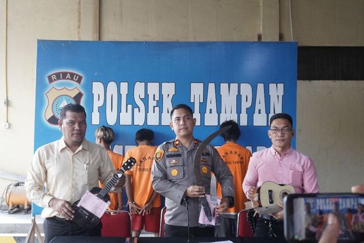 Kapolsek Tampan Kompol I Komang Aswatama (tengah) dan anggotanya memperlihatkan barang bukti yang disita dari empat pelaku penganiayaan seorang karyawan Indomaret di Kecamatan Tuah Madani, Kota Pekanbaru, Riau, Kamis (19/1/2023).