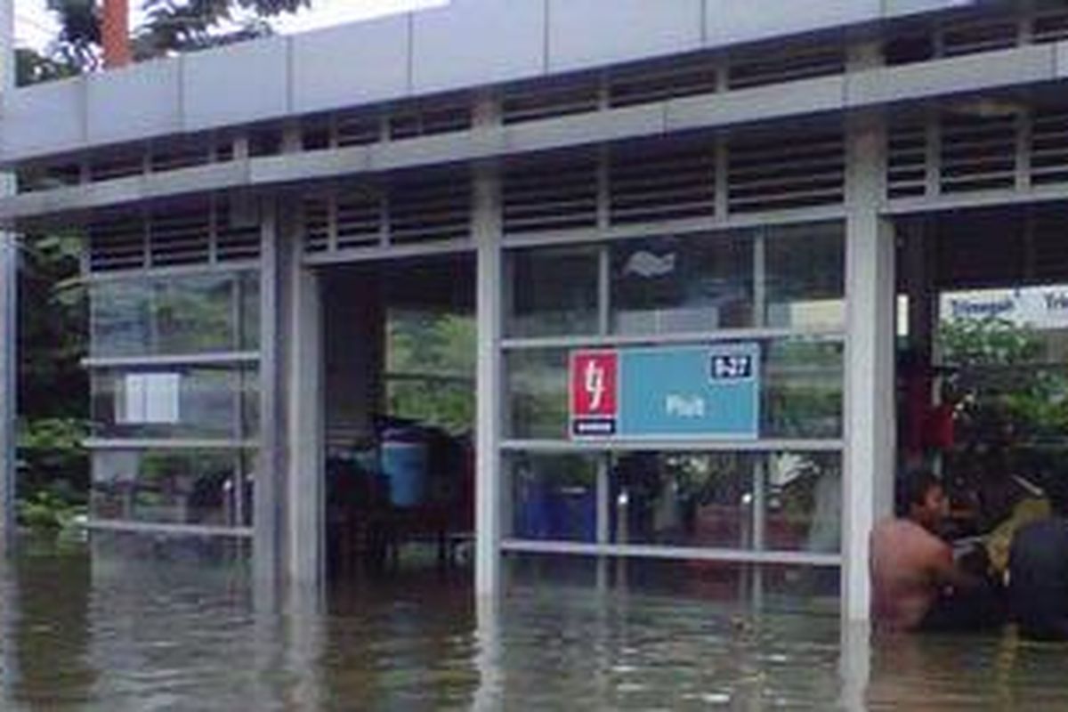 Sebagian warga memilih untuk bertahan di Halte Bus Transjakarta Pluit, Jakarta Utara, Sabtu (19/1/2013). Banjir di kawasan tersebut mencapai ketinggian 1,5 hingga 2 meter akibat meluapnya waduk Pluit.