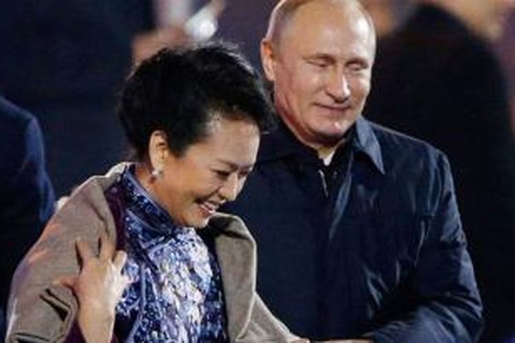 Presiden Rusia Vladimir Putin memberikan mantel tebalnya untuk ibu negara China Peng Liyuan yang terlihat kedinginan.