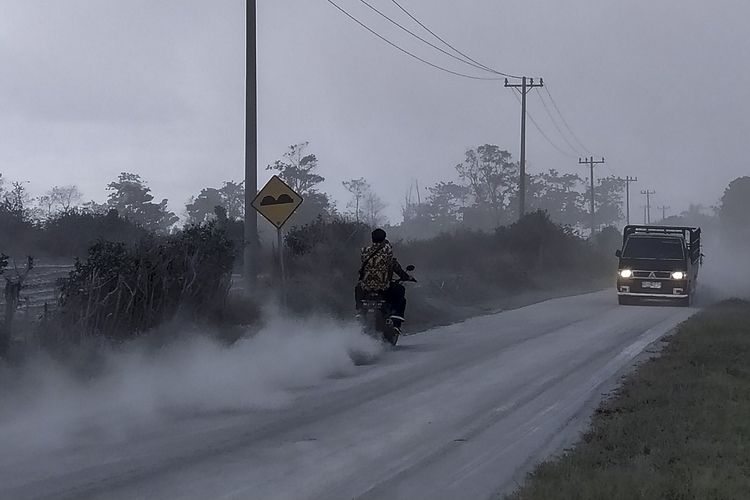 Sejumlah kendaraan melintas di jalan yang dipenuhi debu vulkanik pasca erupsi Gunung Sinabung,  di Desa Sigarang-garang, Karo, Sumatera Utara, Sabtu (8/8/2020). Gunung Sinabung erupsi dengan tinggi kolom 2.000 meter. ANTARA FOTO/Sastrawan Ginting/Lmo/hp.
