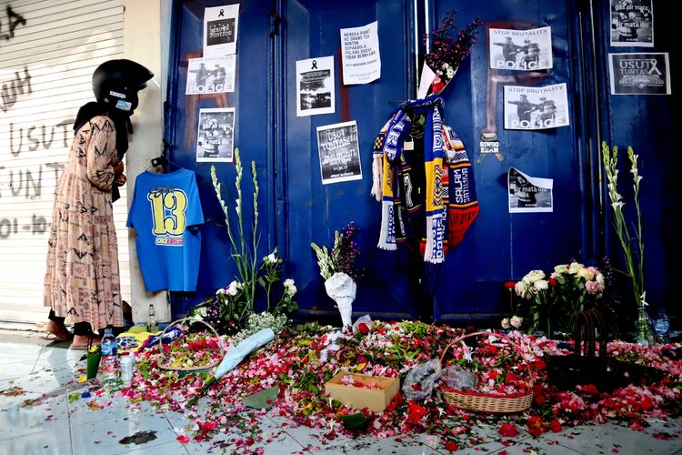 Seorang ibu mengintip dari sela-sela pintu pasca tragedi yang terjadi pada pekan ke-11 Liga 1 2022-2023 seusai pertandingan bertajuk Derbi Jawa Timur, Arema FC melawan Persebaya Surabaya di Stadion Kanjuruhan Kepanjen, Kabupaten Malang, Senin (3/10/2022) siang.