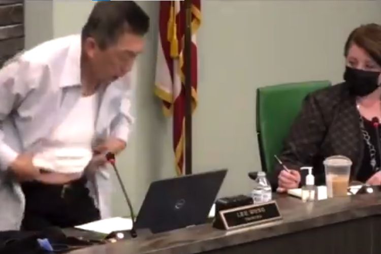 Tangkapan layar dari video saat Lee Wong pejabat dewan kota Cincinnati, Amerika Serikat, mengangkat baju ketika rapat dan memperlihatkan bekas luka perang di dadanya. Ia melakukannya dalam rangka protes sentimen anti-Asia.