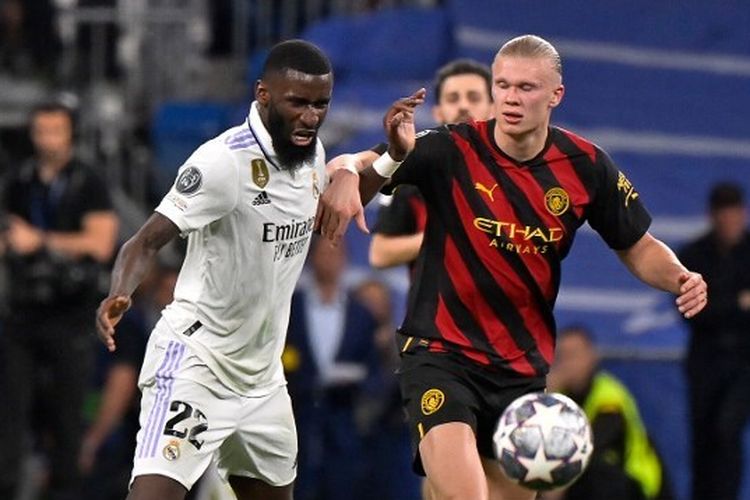 Striker Manchester City, Erling Haaland (kanan), berebut bola dengan bek tengah Real Madrid, Antonio Ruediger, dalam laga leg pertama semifinal Liga Champions 2022-2023. Laga Real Madrid vs Man City yang digelar di Stadion Santiago Bernabeu pada Selasa (9/5/2023) malam waktu setempat tersebut berakhir dengan skor imbang 1-1. (Foto oleh OSCAR DEL POZO / AFP)