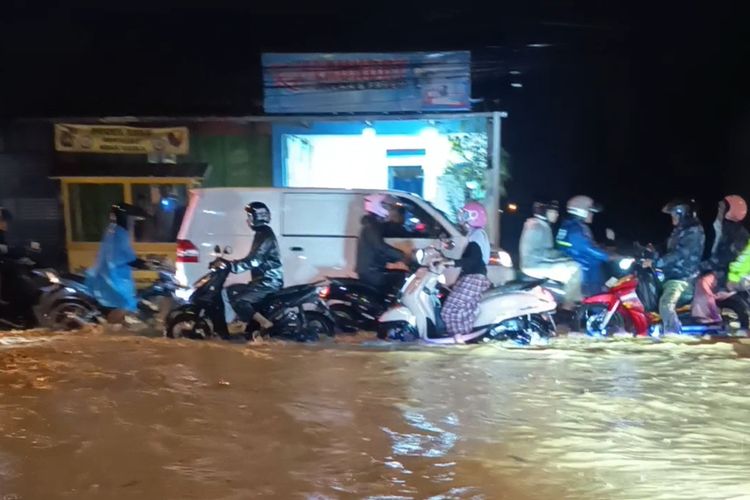 Pwtugas kepolisian tengah mengatur arus lalu lintas di Jalan Bhayangkara, yang tersendat lantaran terendam luapan sungai akibat hujan deras, selain itu beberapa Kecamatan di Kabupaten Bandung, Jawa Barat terendam banjir, Jumat (31/10/2025)
