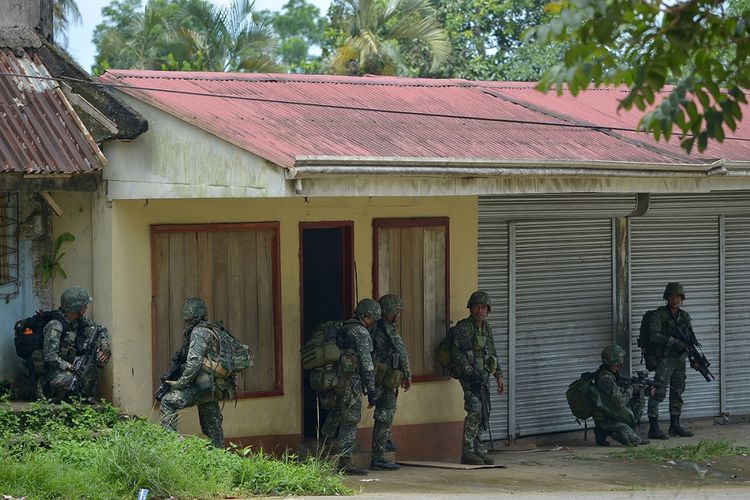 Pasukan pemerintah melakukan patroli di sebuah jalan sepi saat menyerang tempat persembunyian militan pro-ISIS di Kota Marawi, Filipina, Sabtu (3/6/2017). Pertempuran berdarah terjadi antara militer Filipina dengan pasukan Maute di Marawi dalam upaya menangkap pemimpin kelompok Abu Sayyaf, Isnilon Hapilon.