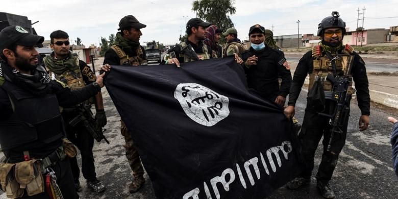 Tentara Irak memperlihatkan bendera ISIS yang diperoleh setelah mereka merebut pertahanan ISIS di sebuah desa di sisi timur kota Mosul.