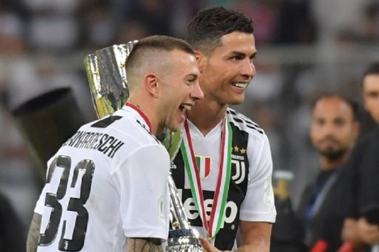 Federico Bernardeschi dan Cristiano Ronaldo mengangkat trofi Piala Super Italia seusai laga Juventus vs AC Milan di Jeddah, 16 Januari 2019. 