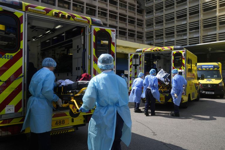 Pekerja medis yang mengenakan alat pelindung memindahkan pasien dari ambulans ke rumah sakit di Hong Kong, Jumat, 4 Maret 2022. 