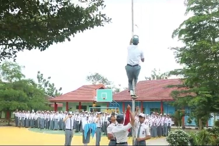 Rizki Muhammad Effendi yang duduk dibangku kelas XII IPS 2 saat membereskan tali bendera yang terputus di SMA Negeri 5 Bengkulu Tengah
