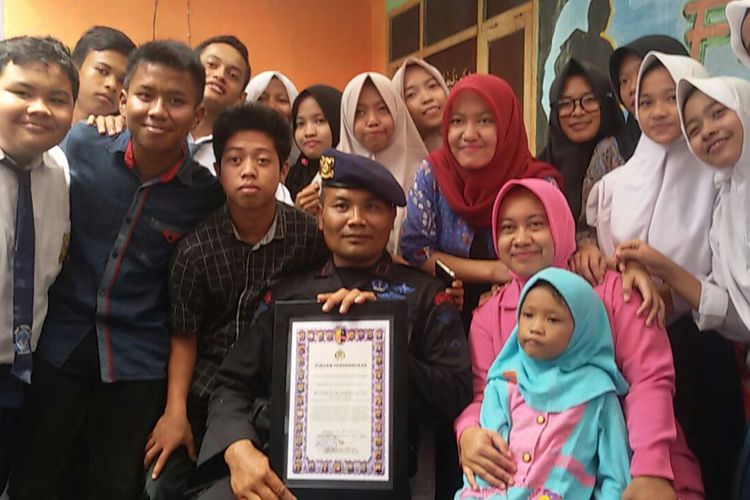 Brigadir Rochmat bersama istri dan anak asuhnya berfoto bersama usai mendapatkan piagam penghargaan dari Kapolda Jatim Irjen Machfud Arifin, Selasa (21/11/2017).