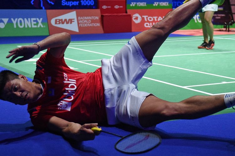 Indonesia's Praveen Jordan (L) playing with Indonesia's Melati Daeva Oktavianti stumbles as they play against Thailand's Dechapol Puavaranukroh and Sapsiree Taerattanachai  during their All England Open Badminton Championships mixed doubles final match in Birmingham, central England, on March 15, 2020. (Photo by Oli SCARFF / AFP)