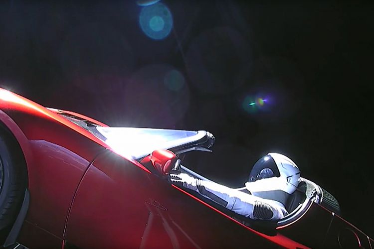 Gambar yang diambil dari video livestream ini menunjukkan manekin bernama Starman duduk di mobil sport Tesla milik Elon Musk yang dibawa roket Falcon Heavy melintasi luar angkasa, Selasa (6/2/2018) waktu setempat. Roket yang diklaim paling kuat di dunia itu memiliki tenaga pendorong setara dengan 18 pesawat Boeing 747, dan diketahui mampu mengirim muatan berat seperti satelit untuk pemerintah dan berbagai perusahaan swasta.