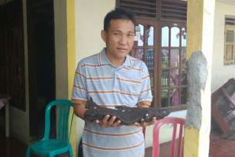 Anggota Polsek Urban Wanea, Manado, Sulawesi Utara, Jefrry Nggala, menunjukkan bangkai ikan langka yang ia temukan di Pantai Kalasey, Minahasa, Sulawesi Utara, Senin (8/8/2016). Ikan itu ditemukan pada Minggu sehari sebelumnya.