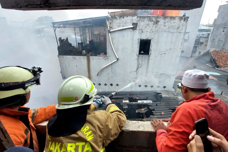 Petugas memadamkan kebakaran yang melanda permukiman warga di Jembatan Besi, Tambora, Jakarta Barat, Jumat (1/4/2022) siang.