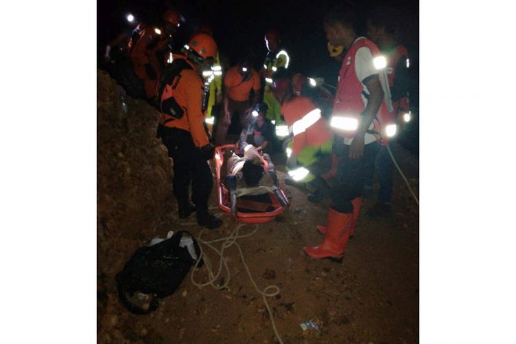 Sejumlah anggota tim SAR mengevakuasi salah seorang korban penambang emas yang tertimbun longsor di Desa Bakan, Kecamatan Lolayan, Kabupaten Bolaang Mongondow, Sulawesi Utara, Selasa (26/2/2019) malam. Sekitar 60 pekerja tertimbun longsor di lokasi penambangan emas tanpa izin tersebut.