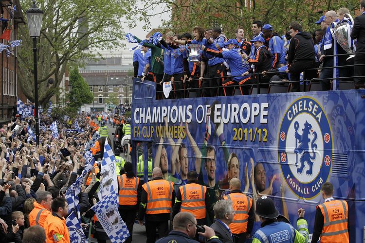 Pemain Chelsea di atas bus merayakan gelar juara Liga Champions dan Piala FA saat parade di jalan dekat stadion Stamford Bridge, Minggu (20/5/2012).
